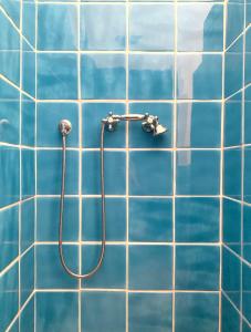 y baño con ducha y azulejos azules. en Masseria Caposella, en Ugento
