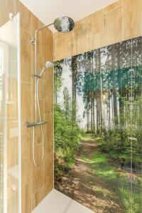 a bathroom with a shower with a painting of a forest at Center Parcs Sauerland Winterberg-Medebach in Medebach
