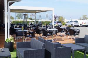 a restaurant with tables and chairs on a patio at Hasle Camping & Hytter in Hasle
