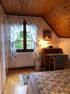 a bedroom with a bed and a desk and a window at Anitas B&B Stockholm/Vällingby in Stockholm