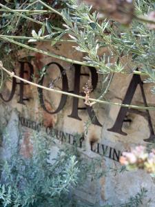 a sign on the side of a stone wall with plants at Opora Country Living in Nafplio