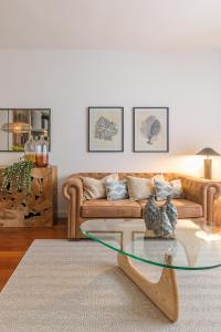 un soggiorno con divano e tavolo in vetro di Madrid Rental Flats a Madrid