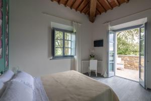 a bedroom with a bed and a sliding glass door at Podere La Doccia in Civitella in Val di Chiana +43 photos