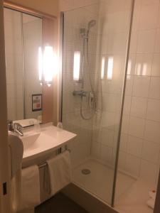 a bathroom with a shower and a sink at Ibis Évry-Courcouronnes in Evry-Courcouronnes