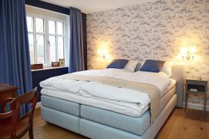 吕丁豪森Hotel No. 11的一间卧室配有一张蓝色和白色壁纸的大床