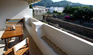 balcone con tavolo, sedie e vista di Luxury Room Vittorio Emanuele II a Città di Lipari