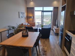 eine Küche und ein Wohnzimmer mit einem Tisch und Stühlen in der Unterkunft Menlyn Apartment in Pretoria
