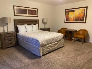 1 dormitorio con 1 cama, mesa y sillas en Eagle Hotel en Palmer