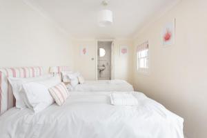 ブライトン＆ホーブにあるBrunswick Patio Apartmentの白い壁の客室内の白いベッド2台