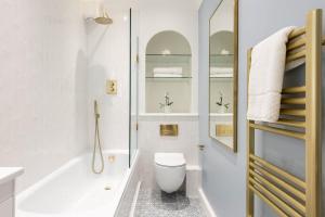 uma casa de banho com uma banheira, um WC e um lavatório. em Brunswick Patio Apartment em Brighton & Hove