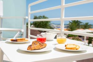 uma mesa branca com pratos de comida e bebidas em Hotel Corallo em Numana