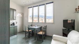 a living room with a table and chairs and a tv at Italianway - Roma 70 in Sanremo