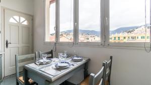 a dining room table with a view of a city at Italianway - Roma 70 in Sanremo