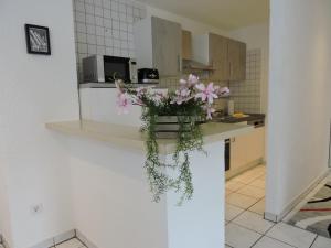 a vase of flowers on a counter in a kitchen at Monteurwohnung Monti 1 in Saarbrücken +4 photos