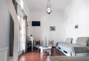 a white bedroom with a bed and a table at DIMITRIOS in Skiros