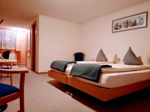 a bedroom with a large bed in a room at Hotel Restaurant Waldrand , Isenfluh 