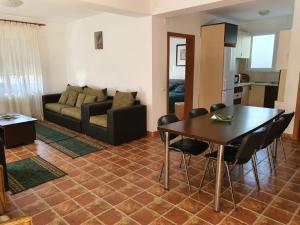 ein Wohnzimmer mit einem Tisch, Stühlen und einem Sofa in der Unterkunft Club Cristal Apartments in Neptun