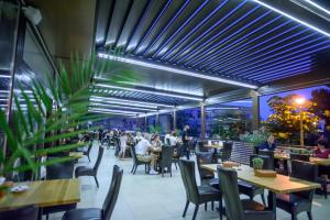 a restaurant with tables and chairs and people sitting at Hotel Tomis in Mamaia
