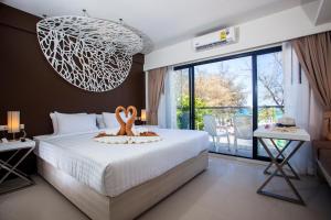 um quarto com uma cama e um lustre em Coral Inn em Praia de Karon