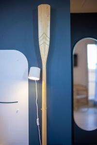 a lamp next to a blue wall with a wooden pole at L'Eautel Toulon Centre Port in Toulon