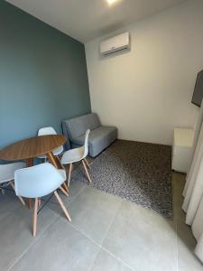 een kamer met een tafel en stoelen en een bank bij Village dos Gerânios in Florianópolis