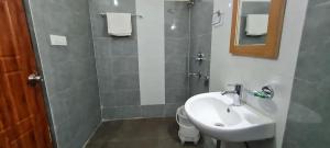 a bathroom with a sink and a toilet and a mirror at Shivansh Inn Resort in Rishīkesh