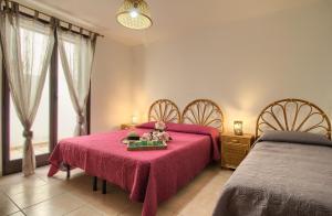 a bedroom with two beds and a table with flowers on it at Villetta Daniela Fronte Spiaggia in Marina di Pescoluse