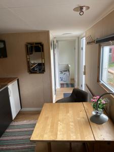 a living room with a wooden table and a kitchen at SoegaardensBB in Stenløse
