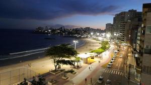 vista para uma praia à noite com carros estacionados em Apartamento FRENTE PARA 0 MAR - PÉ NA AREIA - 3 SUITES COM AR CONDICIONADO, 2- VAGAS DE GARAGEM - FINAMENTE DECORADO - PRAIA DO MORRO-INTERNET -WI-FI -TV COM SERVIÇOS DE DISNEY PLUS - NETFLIX -HBO MAX -STAR MAX - JOGOS AMAZON FIRE STICK - ALEXIA em Guarapari