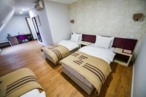 a room with three beds in a room at Hotel Zepter Palace in Banja Luka
