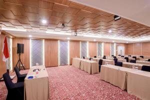a large room with tables and chairs in it at Grand Senyum Hotel, Tugu Yogyakarta in Yogyakarta +14 photos