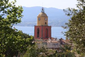 un bâtiment avec une tour d'horloge en haut dans l'établissement bleulagon, à Saint-Tropez