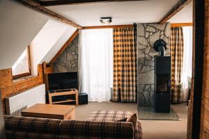a living room with a couch and a tv at APLEND Hotel Kukučka in Tatranská Lomnica +117 photos