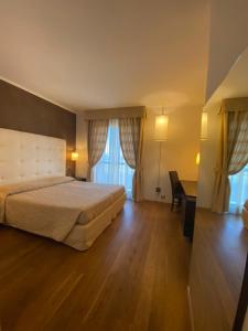 Hotel Rioverde في Pralormo: غرفة نوم بسرير ومكتب في غرفة
