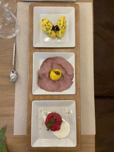 four plates with different types of food on a table at Hotel Rioverde in Pralormo