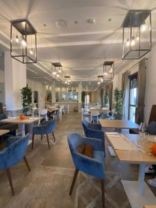 a dining room with blue chairs and tables at Hotel Rioverde in Pralormo