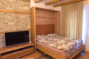 a bedroom with a bed and a flat screen tv at Луксозен, светъл апартамент в Банско, близо до лифт in Bansko