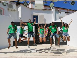 a group of people in green shirts jumping in the air at Hotel Castiglione in Ischia
