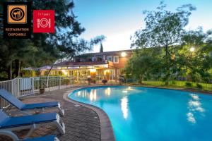 a swimming pool in front of a house at ibis Brignoles Provence Verte in Brignoles