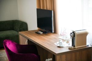 a room with a tv and a table with a chair at Hotel Zepter Palace in Banja Luka