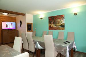 ein Esszimmer mit einem Tisch und Stühlen sowie einem Gemälde an der Wand in der Unterkunft Pokoje Gościnne in Burg Niedzica
