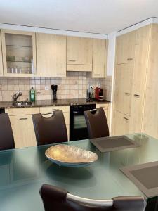 a kitchen with a glass table with chairs and a counter at Bergröschen in Saas-Grund