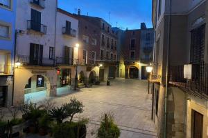 an empty courtyard in a city at night at Casa Moner Loft edifici històric centre medieval de Castelló in Castelló d'Empúries