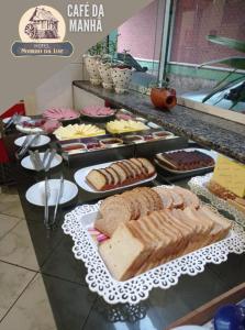 ein Buffet mit Brot und anderen Speisen auf dem Tisch in der Unterkunft Hotel Moinho da Luz - 10 minutos de Lajeado in Arroio do Meio