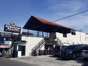 a building with motorcycles parked in a parking lot at Alsalam Syariah Guesthouse in Solo