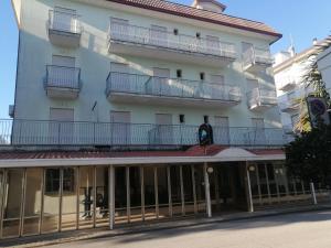 un grande edificio bianco con balconi in cima di Hotel Arborea a Lido di Jesolo