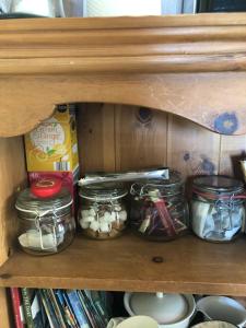 a wooden shelf with jars of food and books at The Stoep in Paignton