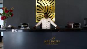 Grand-PopoMillenium Popo Beach Hotel的站在旅馆柜台上的人 更多37张照片