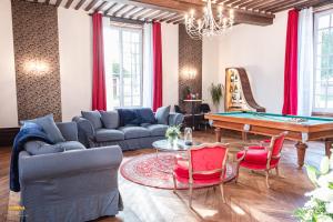 a living room with a pool table and red chairs at Château d'Hermival in Hermival-les-Vaux