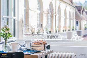 une table avec un panier devant une fenêtre dans l'établissement Château d'Hermival, à Hermival-les-Vaux